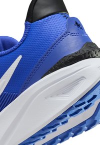 Blauer Sportschuh mit strukturiertem Obermaterial, schwarzem Fersenbereich, weißem Zwischensohlenelement und blauer Gummisohle mit einem Profilmuster für Traktion.