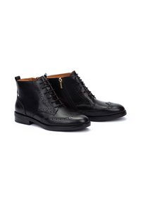 Bottines en cuir noir avec des détails en brogue à bout ailé, fermeture à lacets à l'avant, zip sur le côté et un petit talon carré. Texture lisse avec une finition brillante.