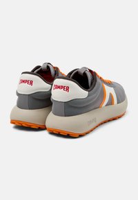 Scarpe atletiche grigie con accenti arancioni, tomaia in rete, suola arrotondata e marchio "CAMPE" sul tallone. Presentano un design a blocchi di colore grigio e bianco.
