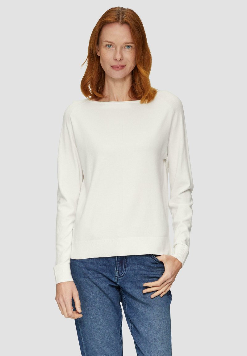 Witte lange mouwen trui met een bootnek en ribbels aan de manchetten. Zachte textuur, gecombineerd met donkerblauwe jeans. Eenvoudig en minimalistisch ontwerp.