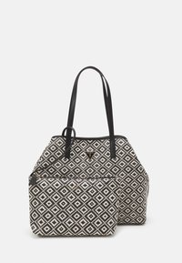 Black and white patterned tote bag with two shoulder straps, featuring a zippered front pocket and a branded logo accent in metal.