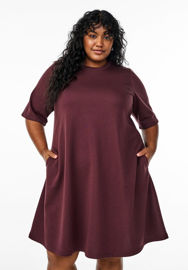 Maroon short-sleeve dress made of soft fabric, featuring a relaxed fit, round neckline, and side pockets at the hem.