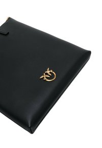 Clutch in pelle nera con una superficie liscia, caratterizzata da un accento dorato di due uccelli attorno a un anello. Chiusura con zip nella parte superiore.