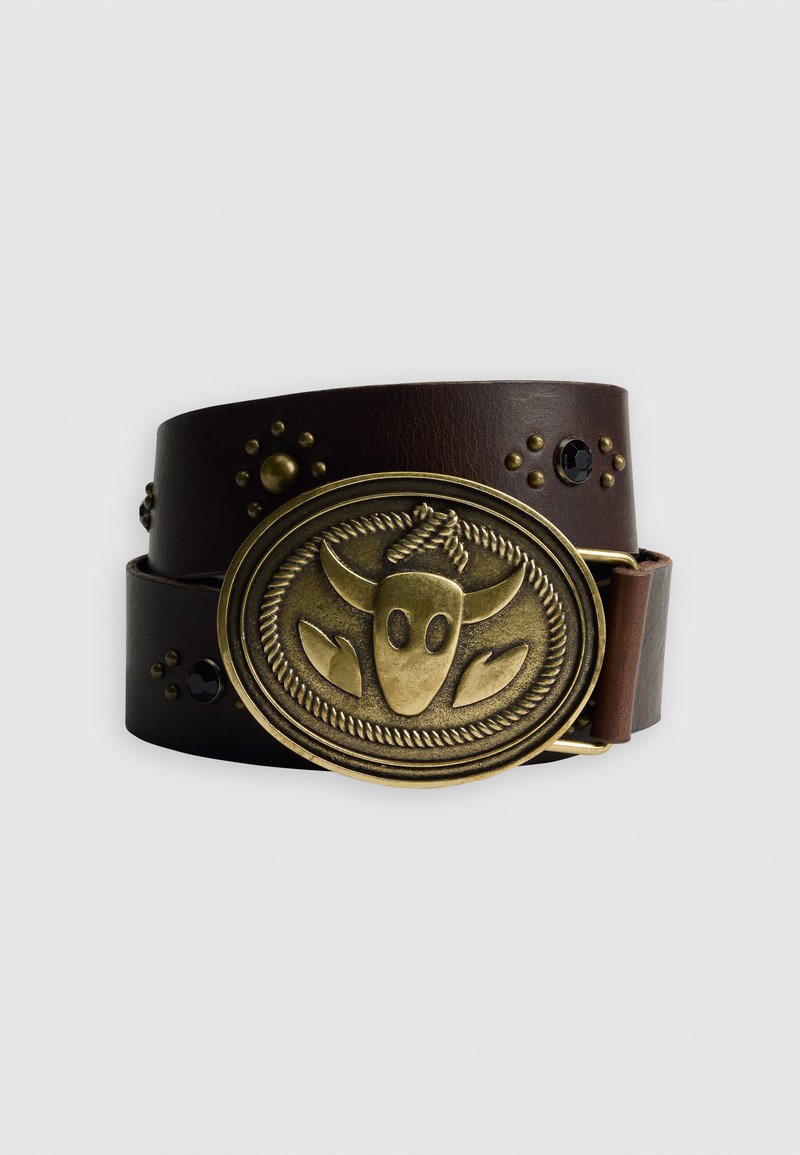 Cintura in pelle marrone con una fibbia ovale in ottone decorata con un design a testa di toro e borchie decorative, inclusi accenti neri sulla cinghia.