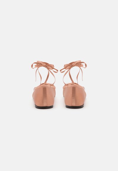 Bailarinas de satén rosa con punta redondeada, lazos en el tobillo y una textura suave. Suela plana y diseño minimalista. Par mostrado desde la parte posterior.