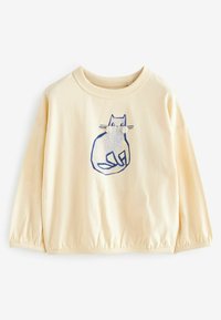 Felpa color crema con maniche lunghe e arricciate. Presenta una grafica di un gatto blu sul davanti, che evidenzia un design giocoso. Texture morbida.