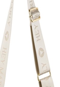 Sangle d'épaule en tissu beige avec le texte tissé "HEY MARLY", dotée d'une boucle en métal doré. Texture lisse et détails de motif subtils.