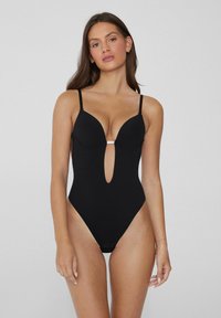 Černé jednodílné plavky s hlubokým výstřihem, tvarovanými košíčky, nastavitelnými ramínky, vysokými průstřihy na nohách a kovovým detailem uprostřed.