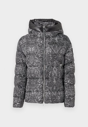 Casaco puffer feito de material com padrão preto e branco, apresentando uma gola alta, fecho de correr e dois bolsos laterais.