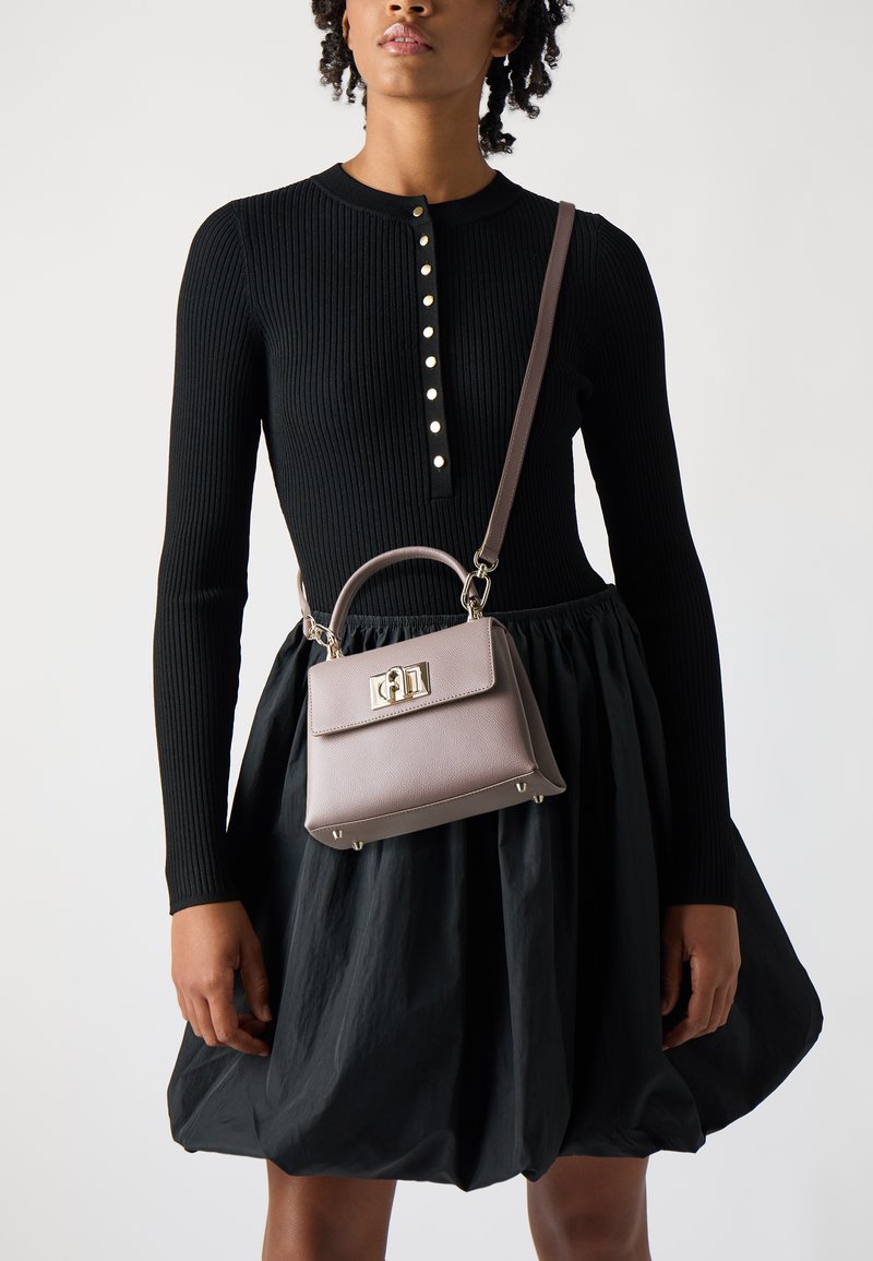 Borsa a mano in pelle grigia con design strutturato, manico superiore e tracolla removibile, dotata di accessori in argento e una texture liscia.