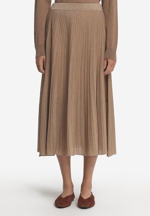Jupe midi plissée en tissu taupe métallisé, avec une finition texturée et une taille ajustée. Associée à des chaussures à enfiler brunes.