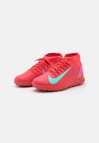 Red athletic shoes with a textured surface, featuring a light blue swoosh logo and pink accents, high-top design with laces.
