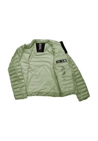 Giacca isolante verde chiaro con texture trapuntata, apertura frontale e accenti neri. Presenta l'etichetta del marchio e icone per resistenza all'acqua e calore.