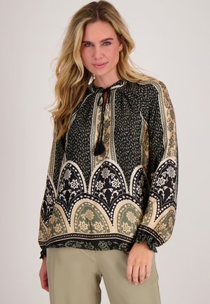 Blouse met een hoge halslijn, voorzien van zwarte en groene bloemenpatronen, elastische manchetten en een trekkoord met kwastjes.