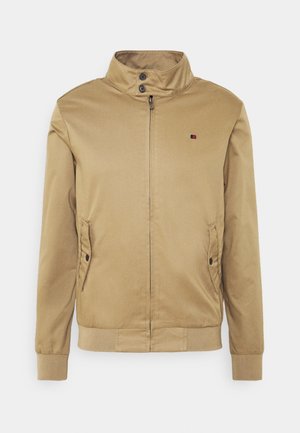 Tan bomberjack met hoge kraag, twee zijzakken, ritssluiting aan de voorkant en knoopdetails. Gladde stof; geribbelde manchetten en zoom.