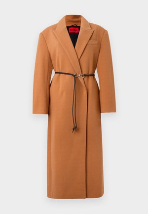 Kamelio vilnos mišinio paltas su įpjovu apykakle ir viena kišene. Su juodu diržu su sidabro spalvos sagtimi. tekstūruotas, vidutinio ilgio dizainas.