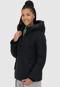 Giacca nera con cappuccio e zip frontale, tasche sul petto doppie e un morbido rivestimento interno. Presenta un cordoncino regolabile sul cappuccio.