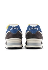 Harmaa ja sininen tennari, jossa on valkoisia yksityiskohtia, mokkaa ja verkkomateriaaleja, pehmustettu nilkkapanta ja "new balance" -logo kantapäällä. Pohja näkyvissä.