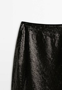 Jupe en sequins noirs avec une texture lisse, un design ajusté et une large ceinture. Les sequins créent un aspect réfléchissant et scintillant.
