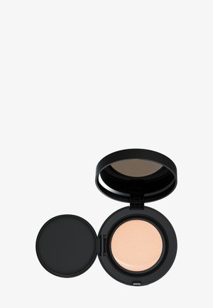 Zwarte compacte verpakking geopend om een lichtbeige cushion foundation te onthullen. Gladde textuur zichtbaar op de cushion, naast een aparte donkere deksel.