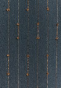 Tessuto di un blu navy con texture, impreziosito da accenti dorati verticali e piccole macchie marroni distribuite in modo irregolare, creando un motivo a strisce.