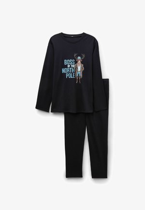 Schwarzes Pyjama-Set mit langen Ärmeln, das eine Grafik eines Rentiers in einem Mantel mit dem Text "BOSS DES NORDPOLS" zeigt, kombiniert mit schwarzen Hosen.