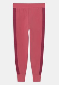 Růžové legíny s úzkým střihem, s tmavě vínovými bočními panely a měkkým, pružným materiálem. Elastický pas pro pohodlí.