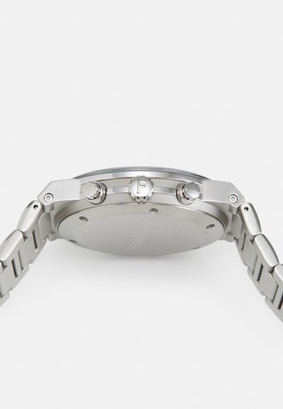 Stainless steel wristwatch with a round case, silver finish, two side buttons, and a textured link bracelet. Back is plain with branding.