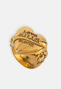 Gold heart-shaped ring featuring engraved text "LOVE KILLS SLOWLY" and floral motifs on the band. Smooth, shiny finish.