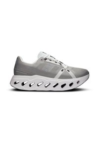 Chaussure de sport légère en maille grise avec des accents blancs. Présente une semelle blanche sculptée à motifs découpés et un système de laçage.