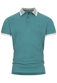 Teal polo shirt lavet af bomuld; har krave i grå og stribede detaljer på ærmerne. To knapper ved halsen, lille logo på brystet.