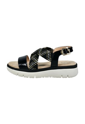 Black sandal with white cushioned sole, crisscross fabric straps with gold and white stitching, and a gold buckle ankle strap.