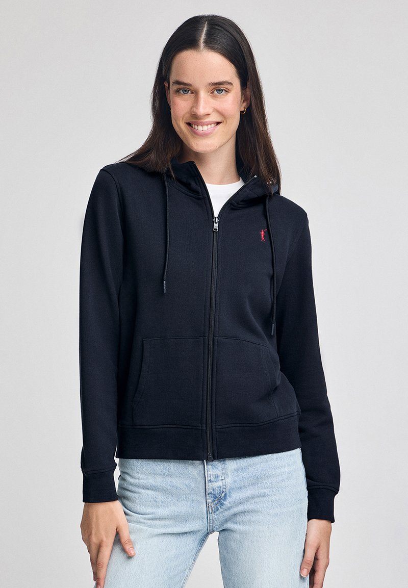 Sudadera negra con cremallera fabricada en mezcla de algodón, con un bolsillo delantero, cordones en la capucha y un pequeño logo rojo en el pecho.