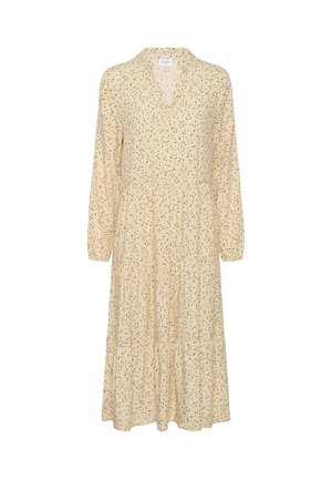 Bež haljina s V-izrezom, dugim rukavima i suknjom s naborima. Ima raspršeni uzorak crnih točkica. Lagani materijal.
