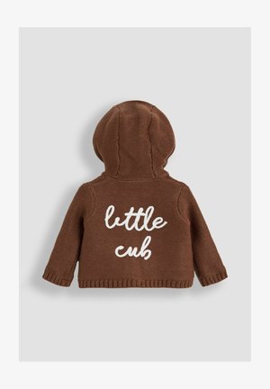 Barna kötött kapucnis pulóver texturált felülettel, hátul fehér "kismackó" felirattal. Lekerekített kapucnival és bordázott mandzsettával rendelkezik.