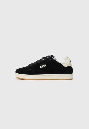 Schwarzer Low-Top-Sneaker mit weißem Fersenakzent, schwarzen Schnürsenkeln, weißer Sohle und FILA-Logo an der Seite und an der Fersenlasche.