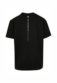 Sorte bomulds T-shirt med korte ærmer. Teksten på bagsiden lyder "KUN De GLEMTE ER RIGTIG DØDE" i hvid lodret skrifttype.