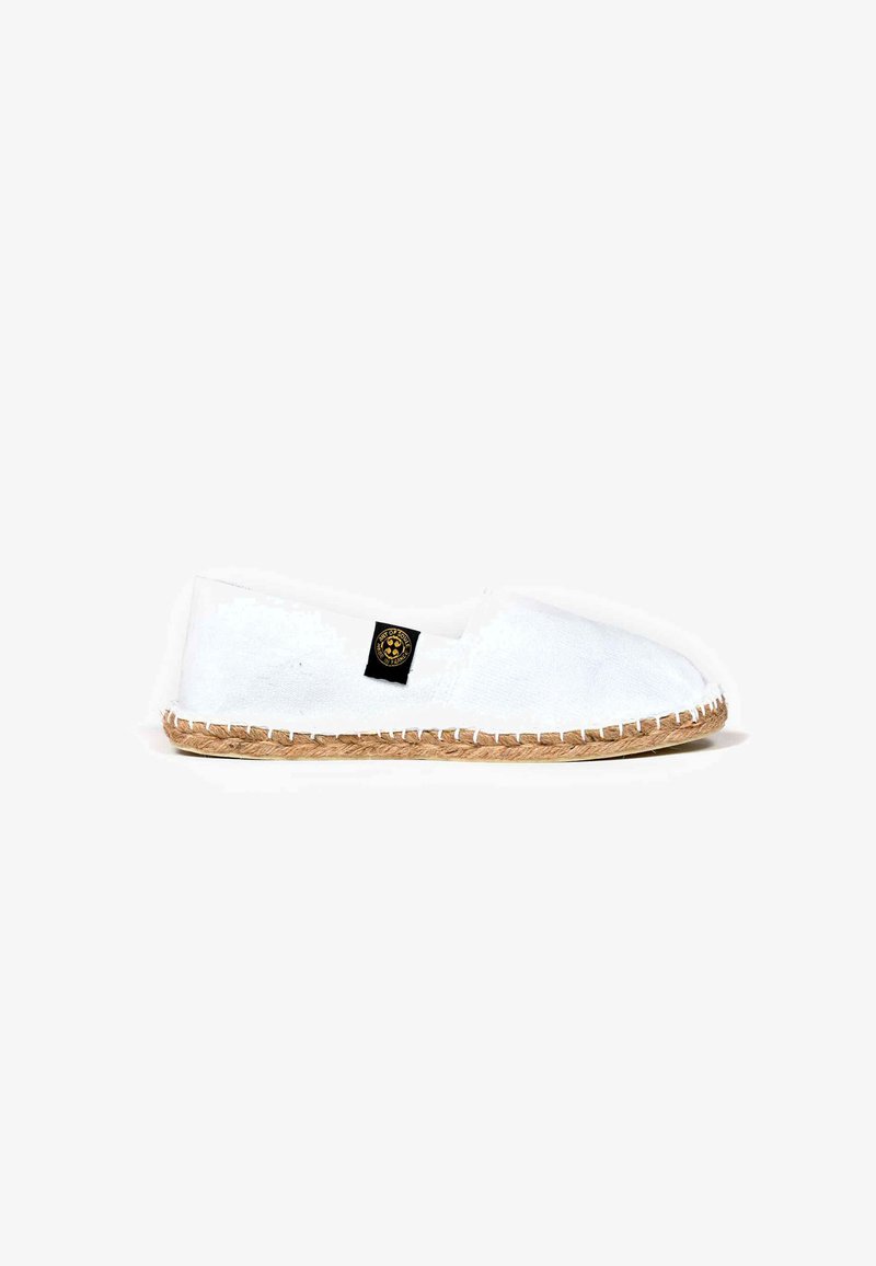 Espadrille en toile blanche avec un bout arrondi, semelle en jute, et étiquette noire. Design simple, matière légère.