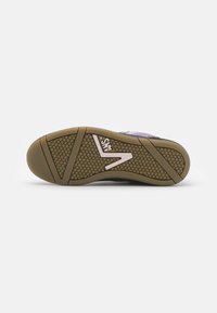 Potplat Vans tenisice s smešnim heksagonalnim uzorkom i ružičastim Vans logotipom, prikazan na običnoj bijeloj pozadini.