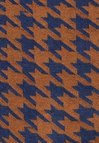 Brązowy i granatowy materiał wzorzysty z motywem houndstooth, charakteryzujący się ostrymi kątami i kontrastującymi kolorami oraz delikatną teksturą dzianiny.