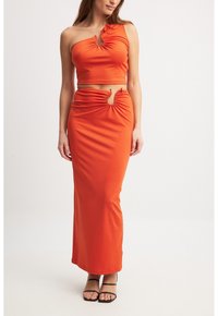 Orange todelt sæt med en one-shoulder cropped top med rynkede detaljer og en maxinederdel med udskæring, begge i et glat stof.