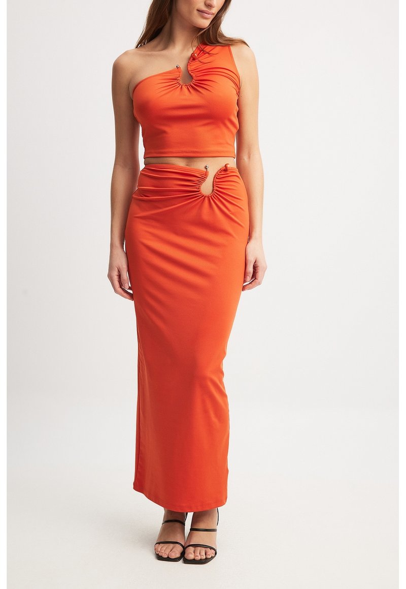 Orange todelt sæt med en one-shoulder cropped top med rynkede detaljer og en maxinederdel med udskæring, begge i et glat stof.