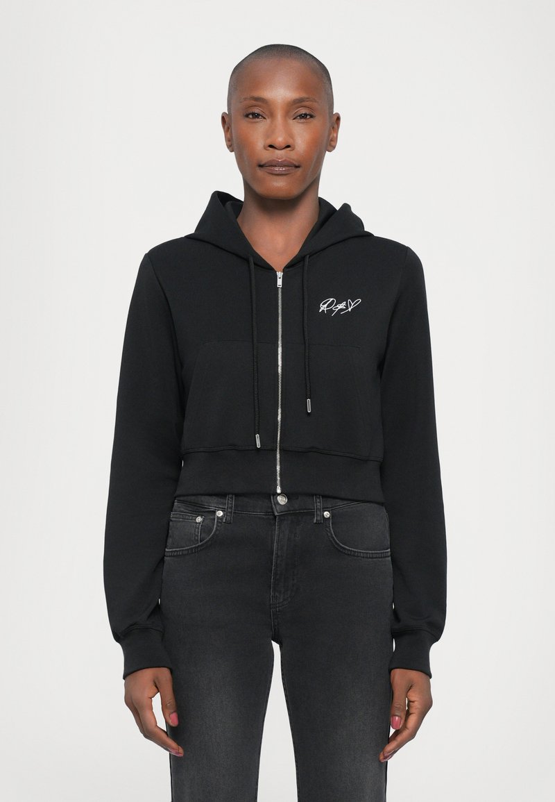Felpa cropped nera realizzata in tessuto morbido; presenta una zip frontale, cappuccio e tasca frontale; include un ricamo bianco del logo sul petto.