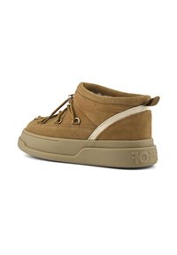Brown suede ankle shoe with beige sole, white side stripe, gold eyelets, and lace-up closure shown from back side angle.
