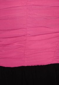 Robe ajustée avec un bodice froncé en rose et une jupe évasée noire. Le tissu semble lisse avec une texture douce et des coutures régulières.