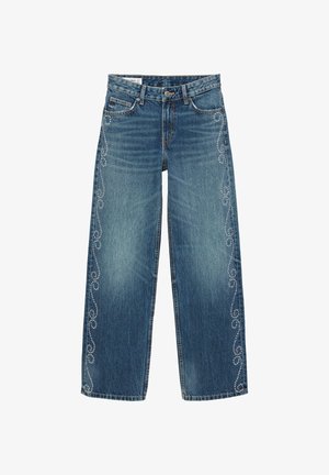 Modré džíny s širokými nohavicami ozdobené vyšívanými vzormi v tvare točivých čiar, ktoré sú lemované malými korálikmi pozdĺž vonkajších švov oboch nohavíc.