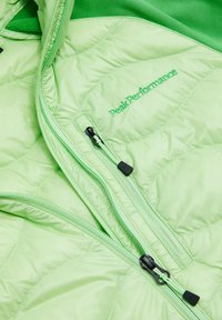 Giacca a vento verde con design trapuntato, texture liscia e dettagli in un verde scuro a contrasto. Include doppie zip e ricamo del marchio.