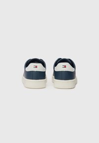 Marineblå lærersneakers med hvite hælkonturer og logo. Designet med en teksturert finish og kontrasterende gummisåler.
