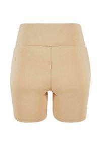 Huidskleurige naadloze shorts met een hoge tailleband. De stof is soepel en aansluitend, met een rechte zoom en geen zichtbare hardware.