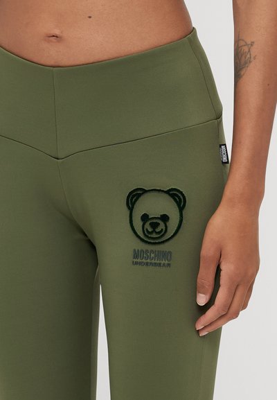 Olivu zaļie legingi ar izceltā lāča logotipu un tekstu "MOSCHINO UNDERBEAR". Gluda tekstūra un augstas jostas vietas dizains ar izšūšanas detaļām.